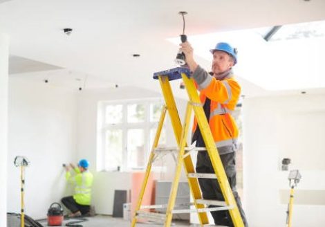 electrician installing downlights